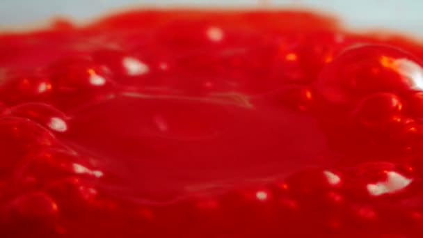 Filmagem de escorrimento vermelho borbulhante pegajoso, close-up — Vídeo de Stock