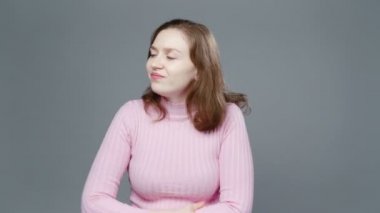 Pembe balıkçı yaka giyen gergin kadının videosu.