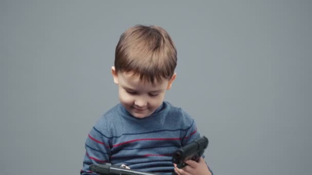 Зйомки чотирирічного хлопчика, який грає з пістолетом — стокове відео