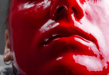 Parlak kırmızı boyalı genç kadın yüzü