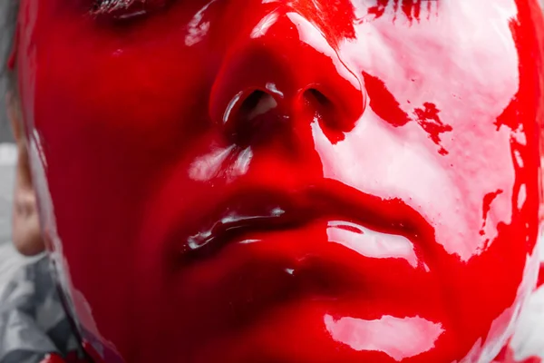 Glossy womans face with spreading red paint — Stock Photo, Image