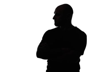 Beyaz arka planda kollarını kavuşturmuş kel bir adamın silueti.