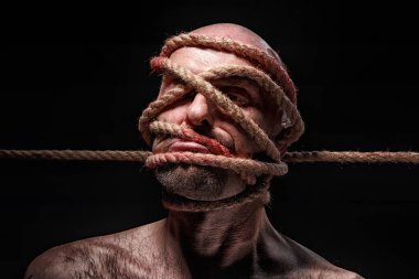 Yüzünde ip olan bağlanmış kel bir adam resmi