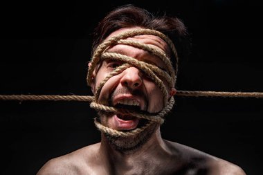 Yüzünde halat olan bağlanmış bir adam resmi