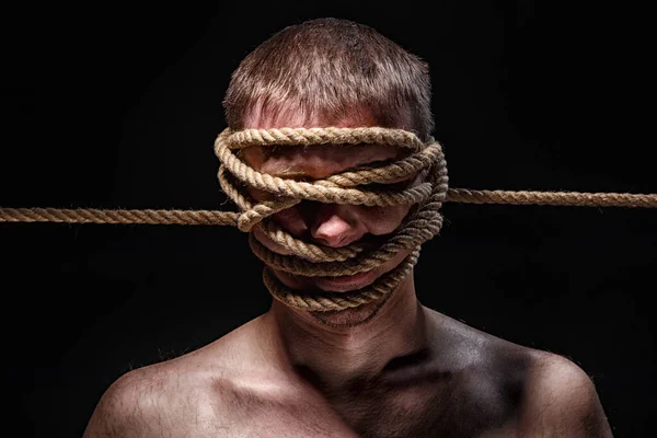 Фото обвязанного человека с веревкой на лице — стоковое фото