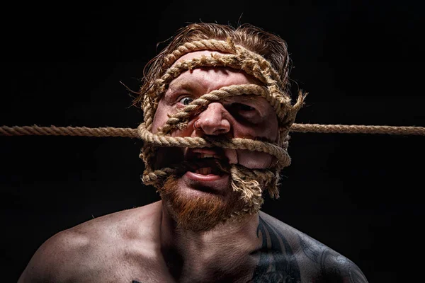 Foto de homem barbudo amarrado com corda no rosto — Fotografia de Stock