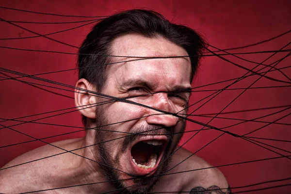 Photo of tangled in black threads brunette man — Stock Photo, Image