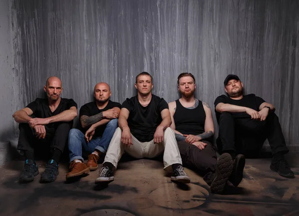 Band of men sitting on dirty floor — Stock Photo, Image