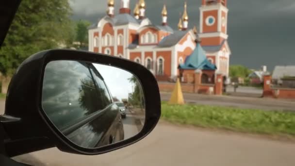 Landskap med kyrka från bilens backspegel — Stockvideo