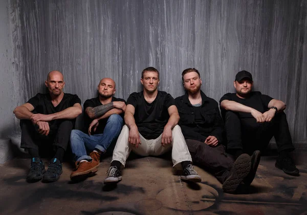 Picture of group of men sitting on dirty floor — Stock Photo, Image