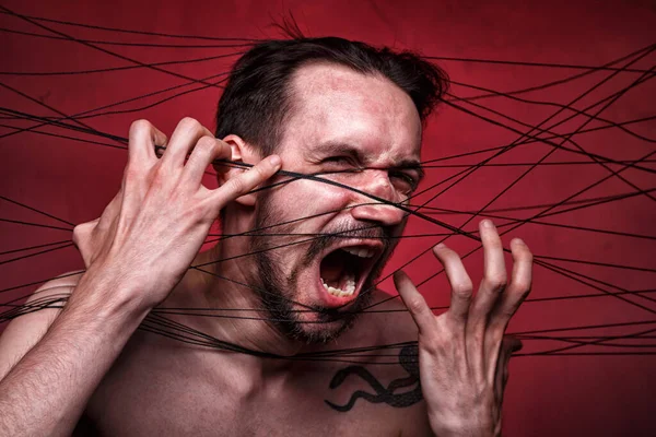 Image of tangled in black threads brunette man — Stock Photo, Image