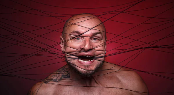 Photo of tangled in threads bald screaming man — Stock Photo, Image