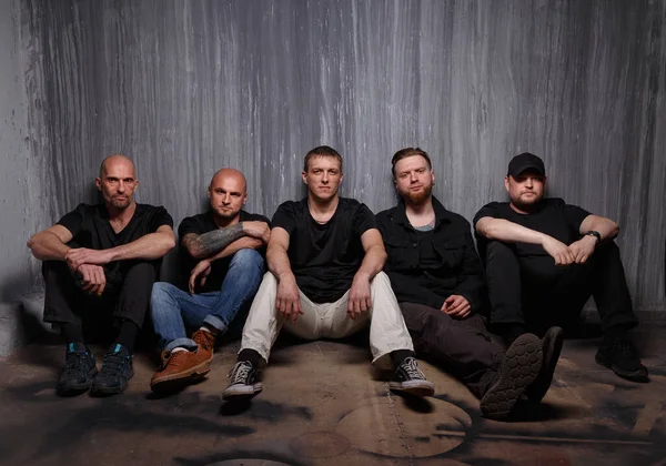 Group of men sitting on dirty floor — Stock Photo, Image