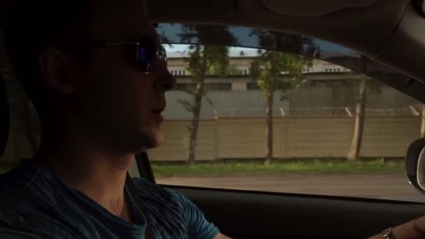 Homem com óculos de sol falando em carro em movimento — Vídeo de Stock