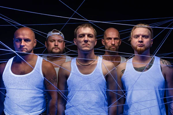 Foto einer Männergruppe, die sich in Fäden im Neonlicht verheddert — Stockfoto