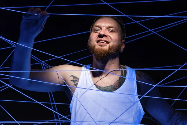 Crazy man tangled in threads in neon light — Stock Photo, Image