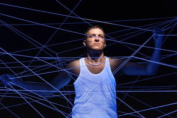 Photo of man tangled in white threads in neon light — Stock Photo, Image