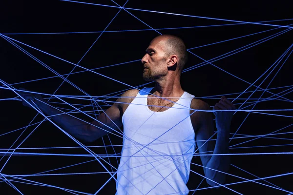 Adult man tangled in threads in neon light — Stock Photo, Image