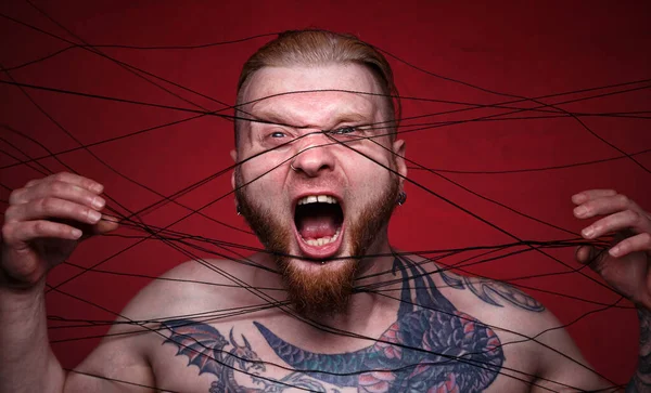Image of tangled in black threads bearded screaming man — Stock Photo, Image