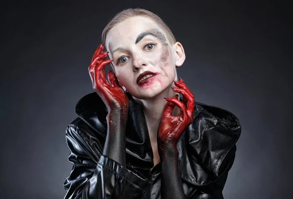 Photo of horror woman in black raincoat with red hands near face — Stock Photo, Image