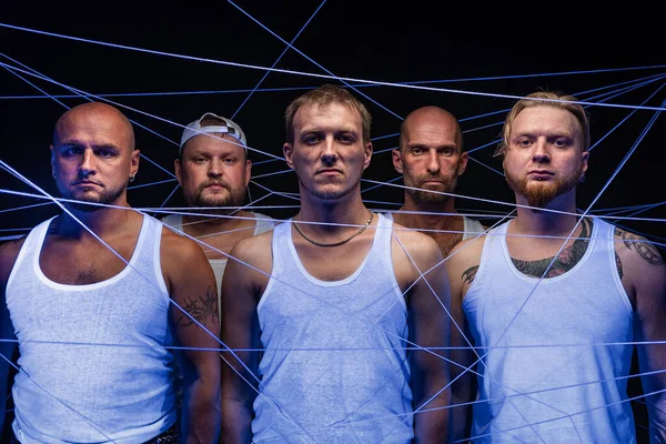 Picture of group of men tangled in threads in neon light — Stock Photo, Image