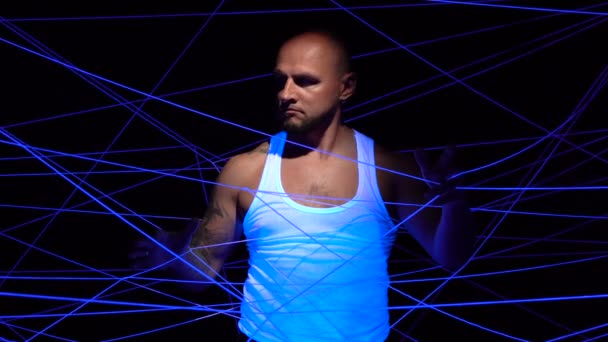 Человек, запутавшийся в белых нитях в ультрафиолете — стоковое видео