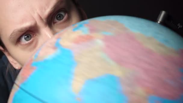 Відео дівчини, дивлячись на обертовий глобус — стокове відео