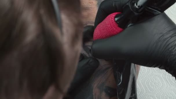 Відео чоловіка, який отримує татуювання в салоні — стокове відео