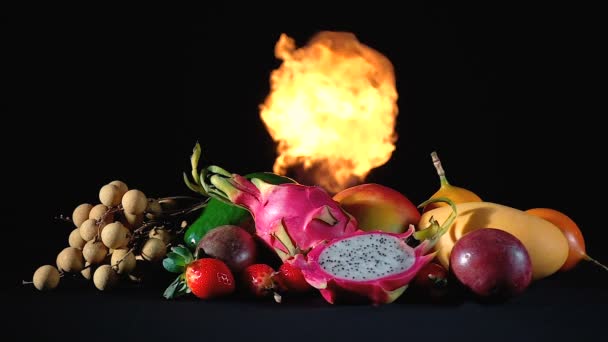 Frutas exóticas en el fuego sobre fondo negro — Vídeo de stock