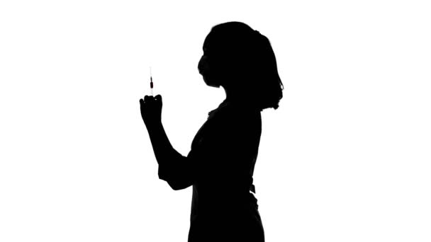 Video of womans silhouette in mask with syringe — Stock Video