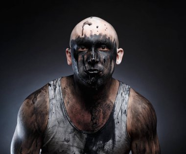 Ağzında siyah yapışkan madde olan kel deli bir adam.