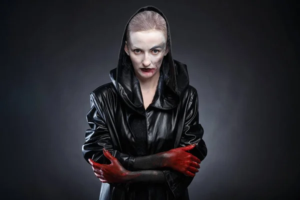 Photo of woman in black leather raincoat with red hands — Stock Photo, Image