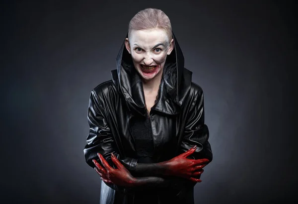 Photo of horror woman in black leather raincoat with red hands — Stock Photo, Image