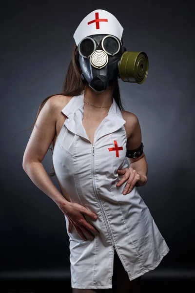 Foto de la joven enfermera morena delgada en máscara de gas Imagen De Stock