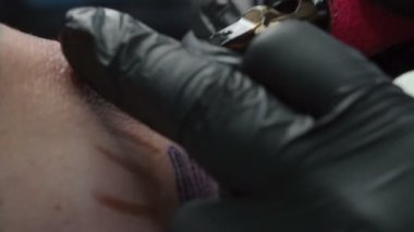 Stüdyoda dövme yaptıran adamın görüntüsü.