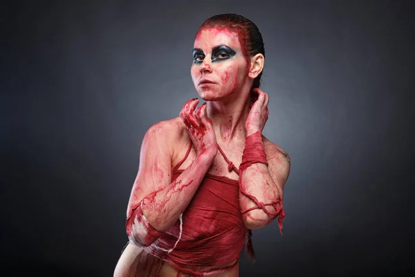 Young girl in fake blood on grey background — Stock Photo, Image