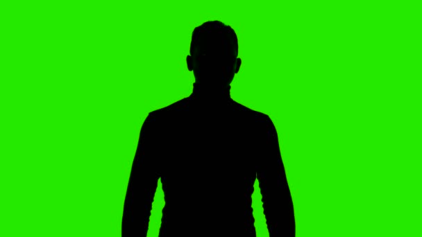 Video van mans silhouet met armen gekruist op geïsoleerde groene achtergrond — Stockvideo