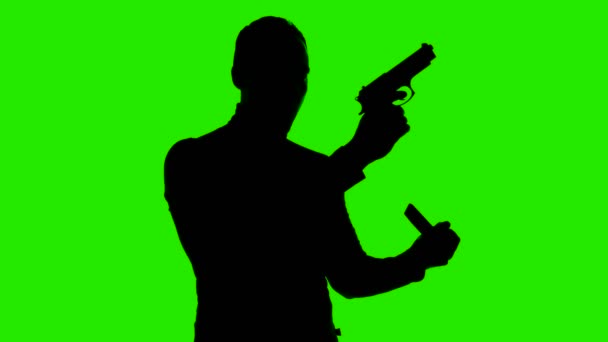 Video av män silhuett med handeldvapen magasin på isolerad grön bakgrund — Stockvideo