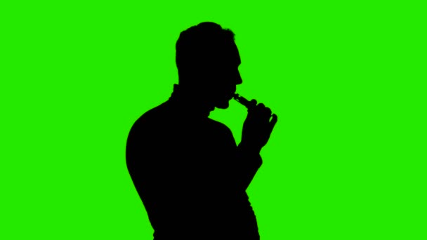 Schieten van mans silhouet met vape op groene achtergrond — Stockvideo