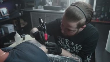 Ustanın cildine siyah dövme yaptırdığı görüntüler.