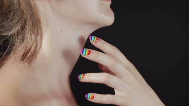 Filmación de las manos con la manicura del arco iris en el cuello de las mujeres desnudas — Vídeo de stock