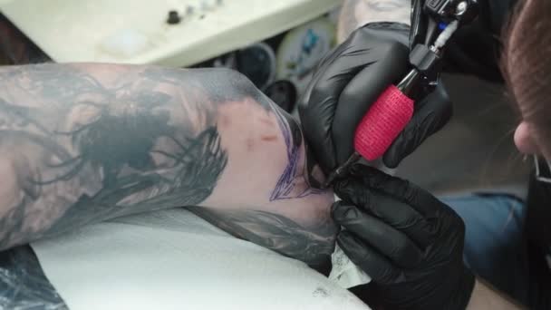 Tir de l'homme faisant le tatouage sur le coude dans le salon — Video