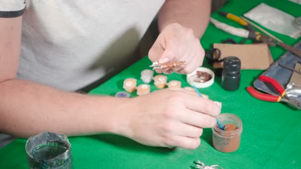Ремесленник, рисующий жестяную игрушку дома — стоковое видео
