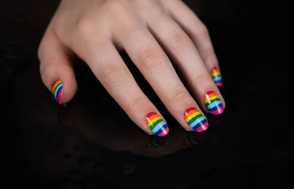 Foto de mão de mulheres com manicure arco-íris — Fotografia de Stock