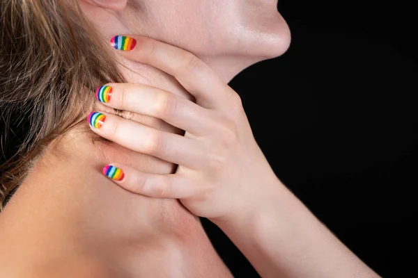 Foto de dedos com manicure arco-íris no pescoço nu — Fotografia de Stock