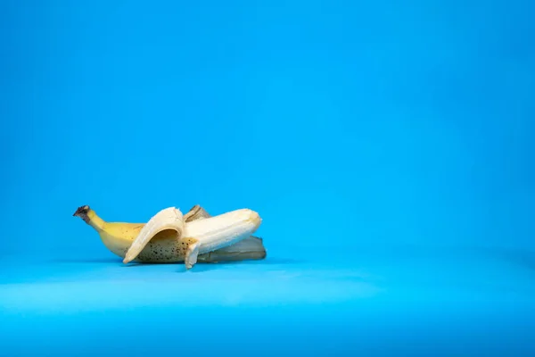 Imagen de plátano fresco pelado sobre fondo azul —  Fotos de Stock