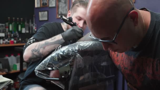 Skott på tatuerare som tatuerar sig i salongen — Stockvideo
