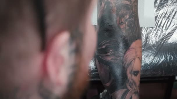 Άνθρωπος να πάρει τατουάζ στον αγκώνα στο σαλόνι, πάνω όψη — Αρχείο Βίντεο