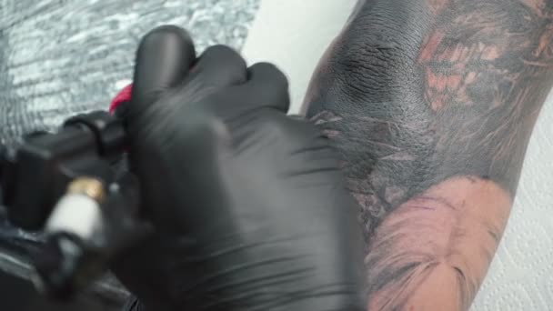 Vidéo de maître se faire tatouer sur le coude dans le salon — Video