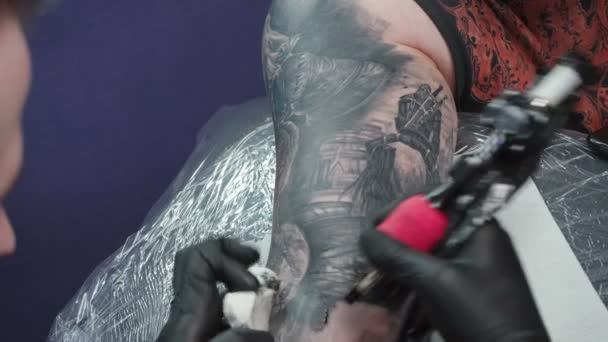 Tiro de tatuador recebendo tatuagem no braço no salão — Vídeo de Stock